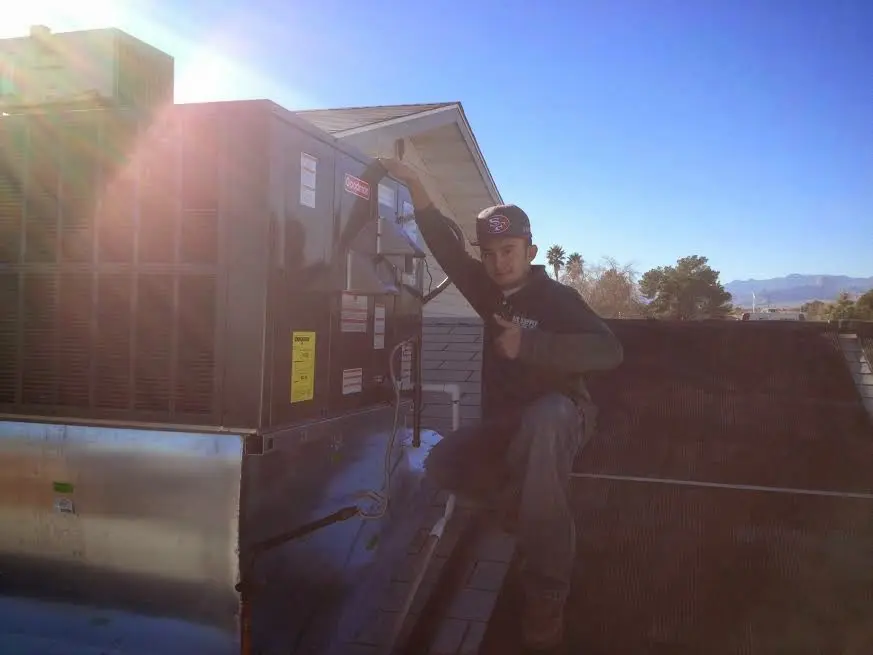 HVAC technician performing Air Duct Cleaning on a rooftop unit in Chesapeake Beach